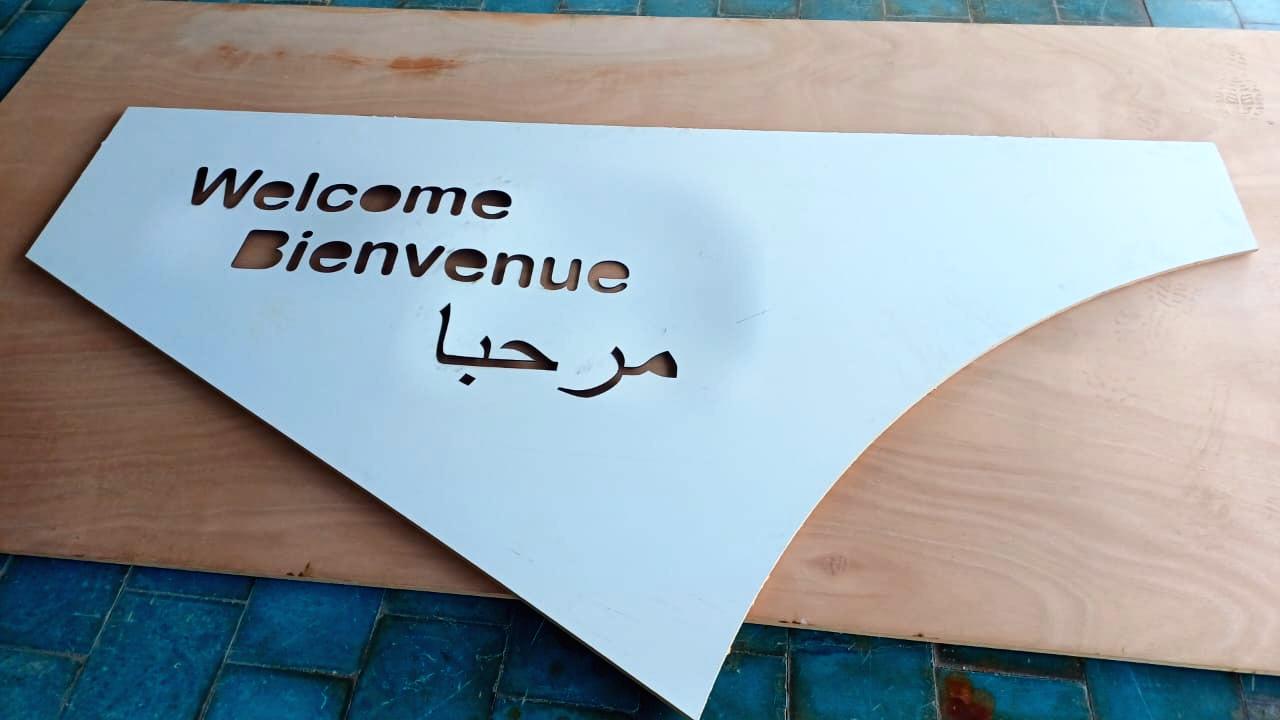 Panneau « Welcome / Bienvenue / مرحبا » découpé en CNC, à l’atelier.